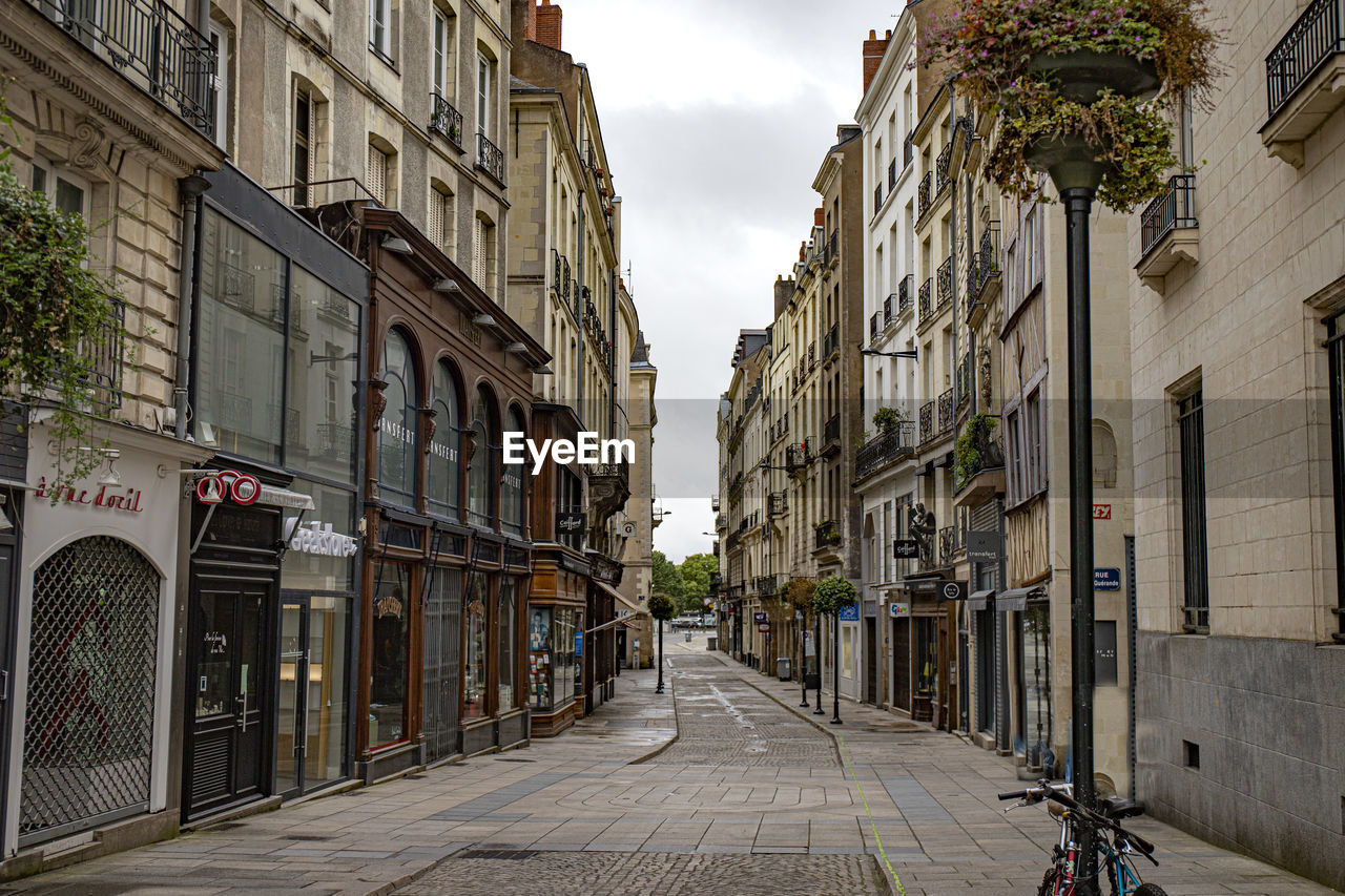 STREET AMIDST BUILDINGS AGAINST SKY