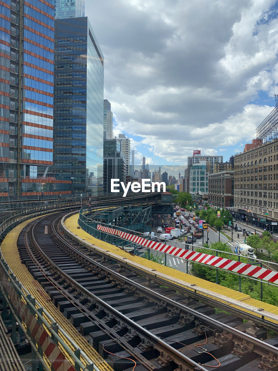 Railroad tracks amidst buildings in city against sky