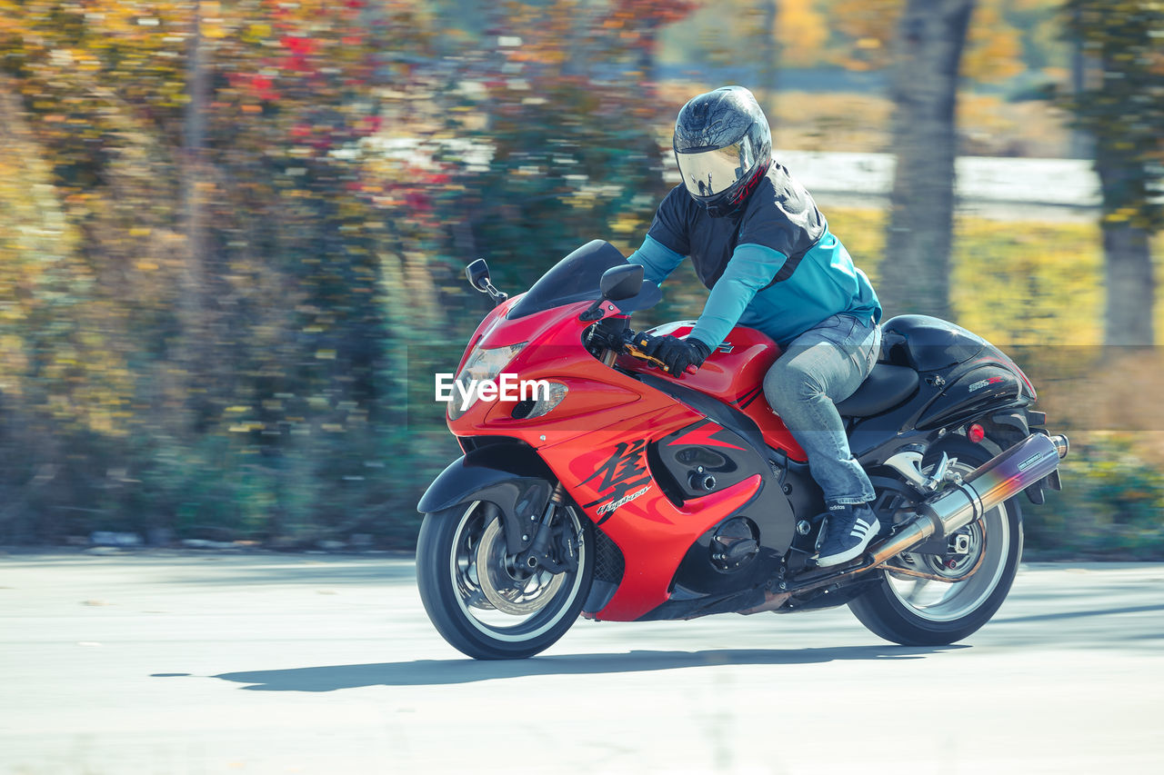 PERSON RIDING MOTORCYCLE ON ROAD