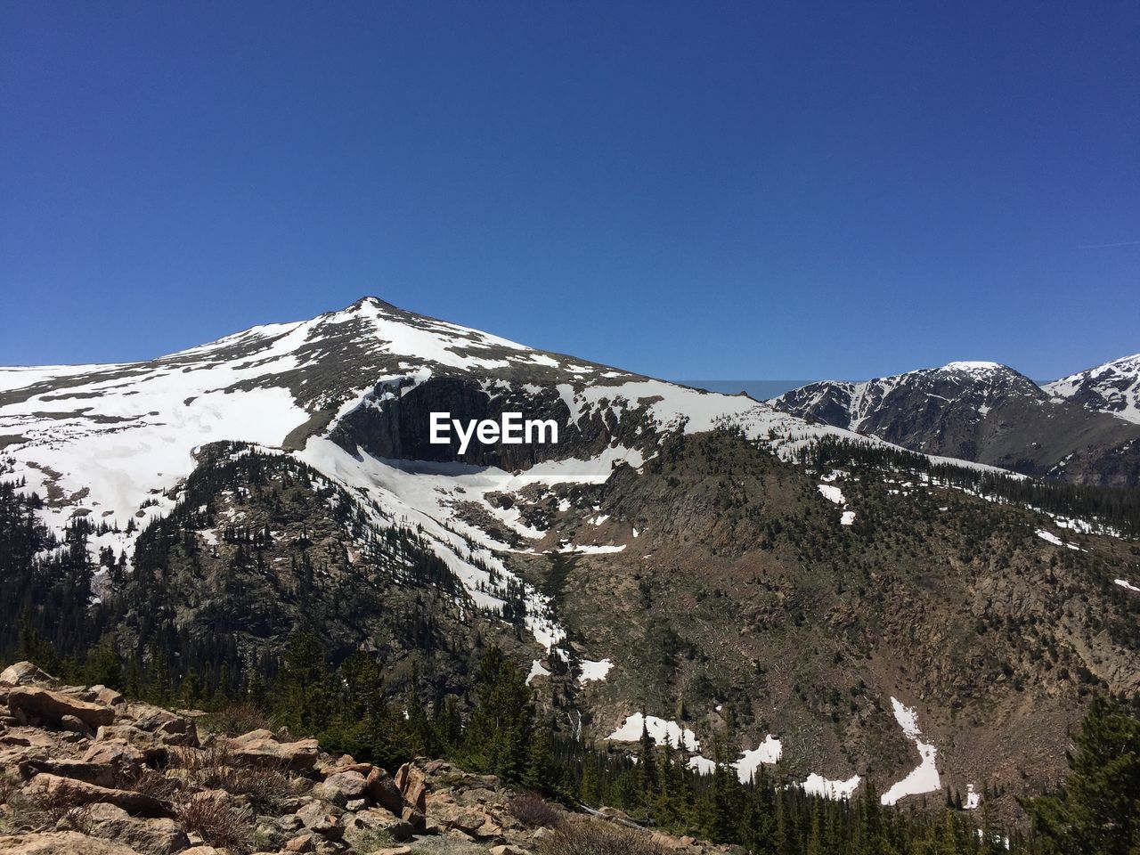 Scenic view of snowcapped mountains against clear blue sky