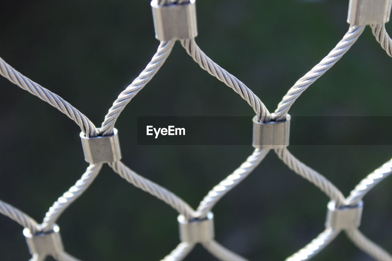 FULL FRAME SHOT OF CHAINLINK FENCE WITH WIRE