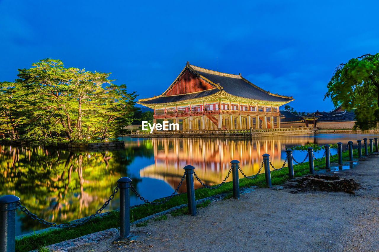 BUILDING BY LAKE AGAINST SKY