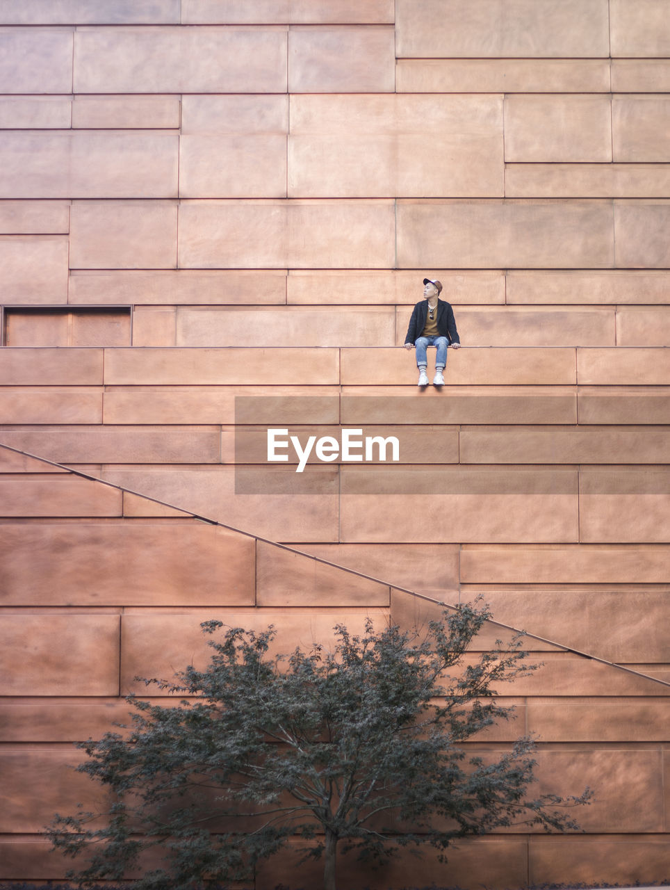 Low angle view of man sitting on building