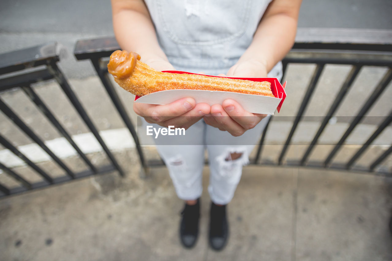 HIGH ANGLE VIEW OF MAN HOLDING ICE CREAM CONE