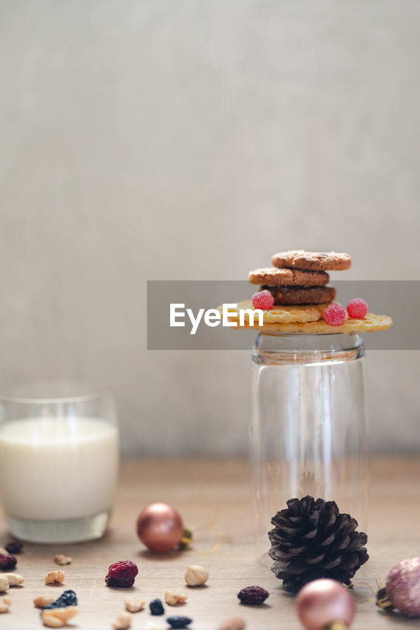 Close-up of milk and cookies with christmas decorations on table