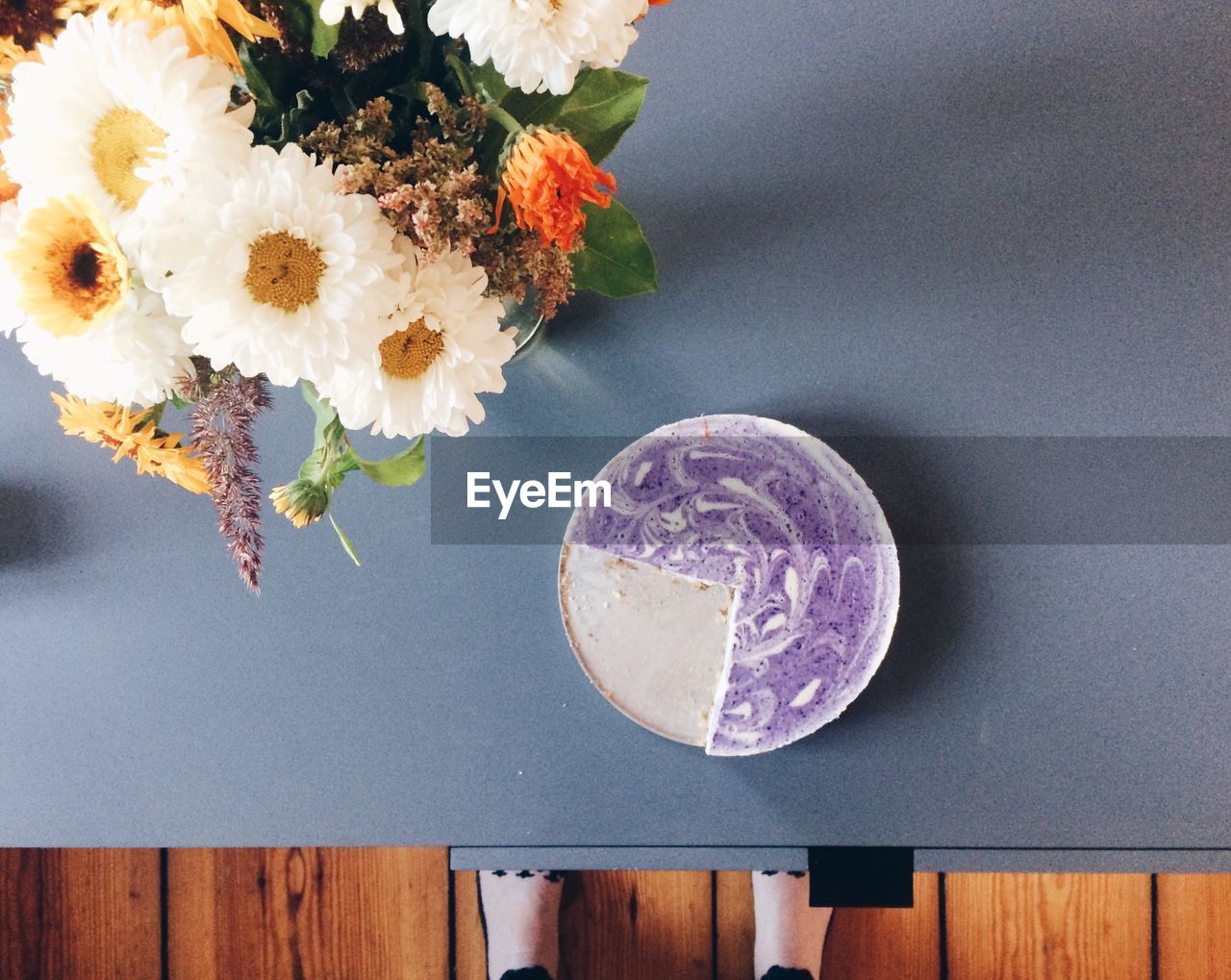 Directly above shot of cake by flower vase on table