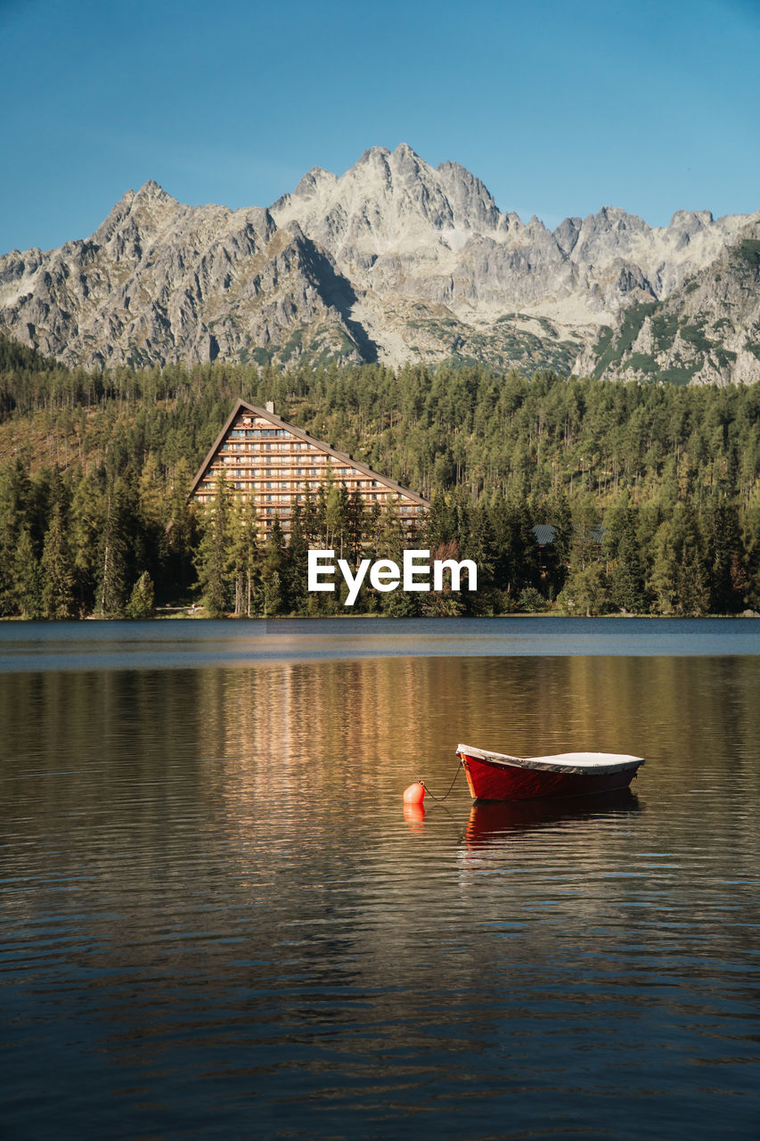 BOAT IN LAKE AGAINST MOUNTAINS