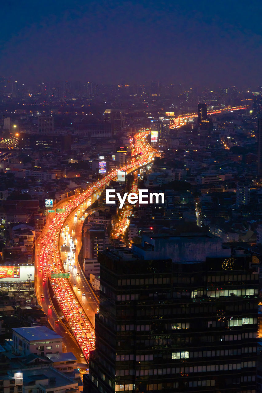 high angle view of illuminated cityscape against sky at night