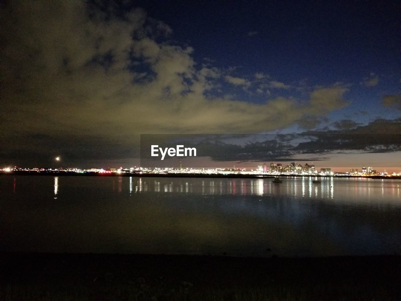 SCENIC VIEW OF ILLUMINATED LAKE AGAINST SKY AT NIGHT