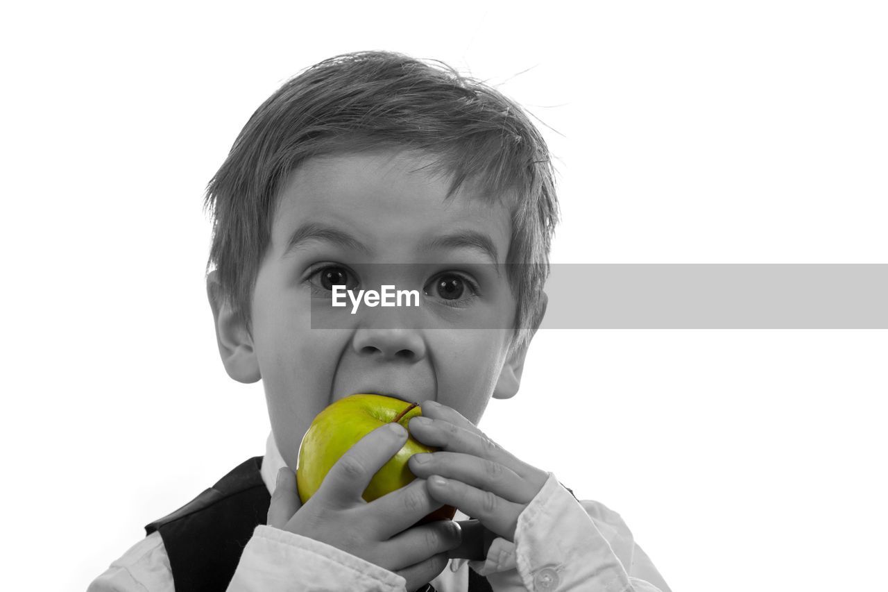 PORTRAIT OF BOY EATING ICE CREAM OVER WHITE BACKGROUND