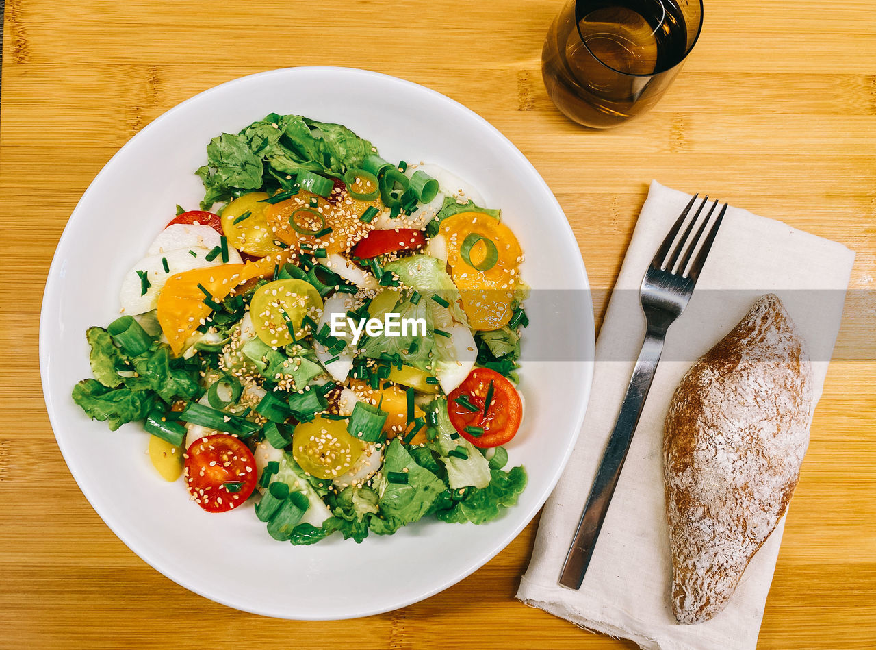 High angle view of annorfanic salad served on table with a side of bread