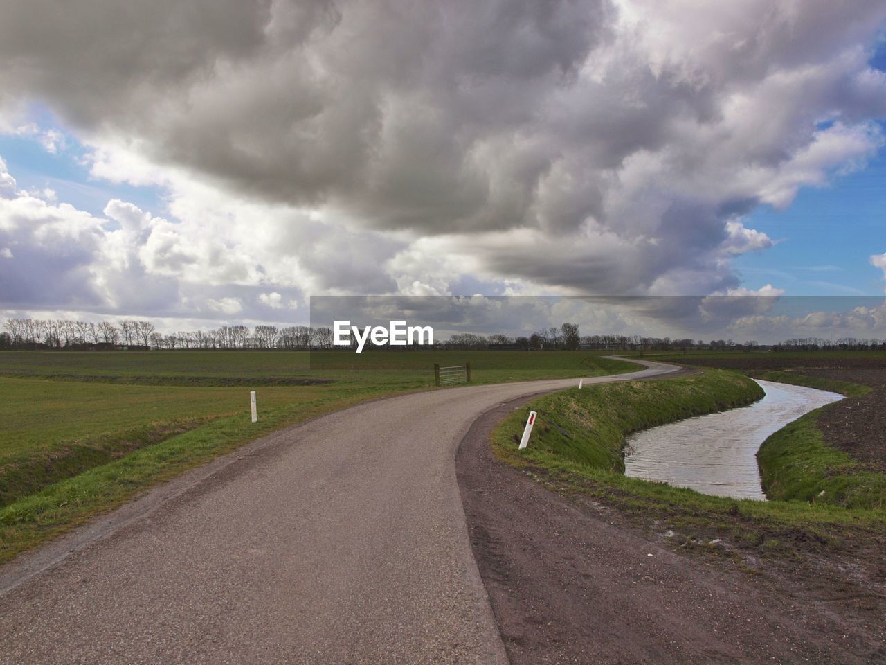 Surface level of country road against cloudy sky