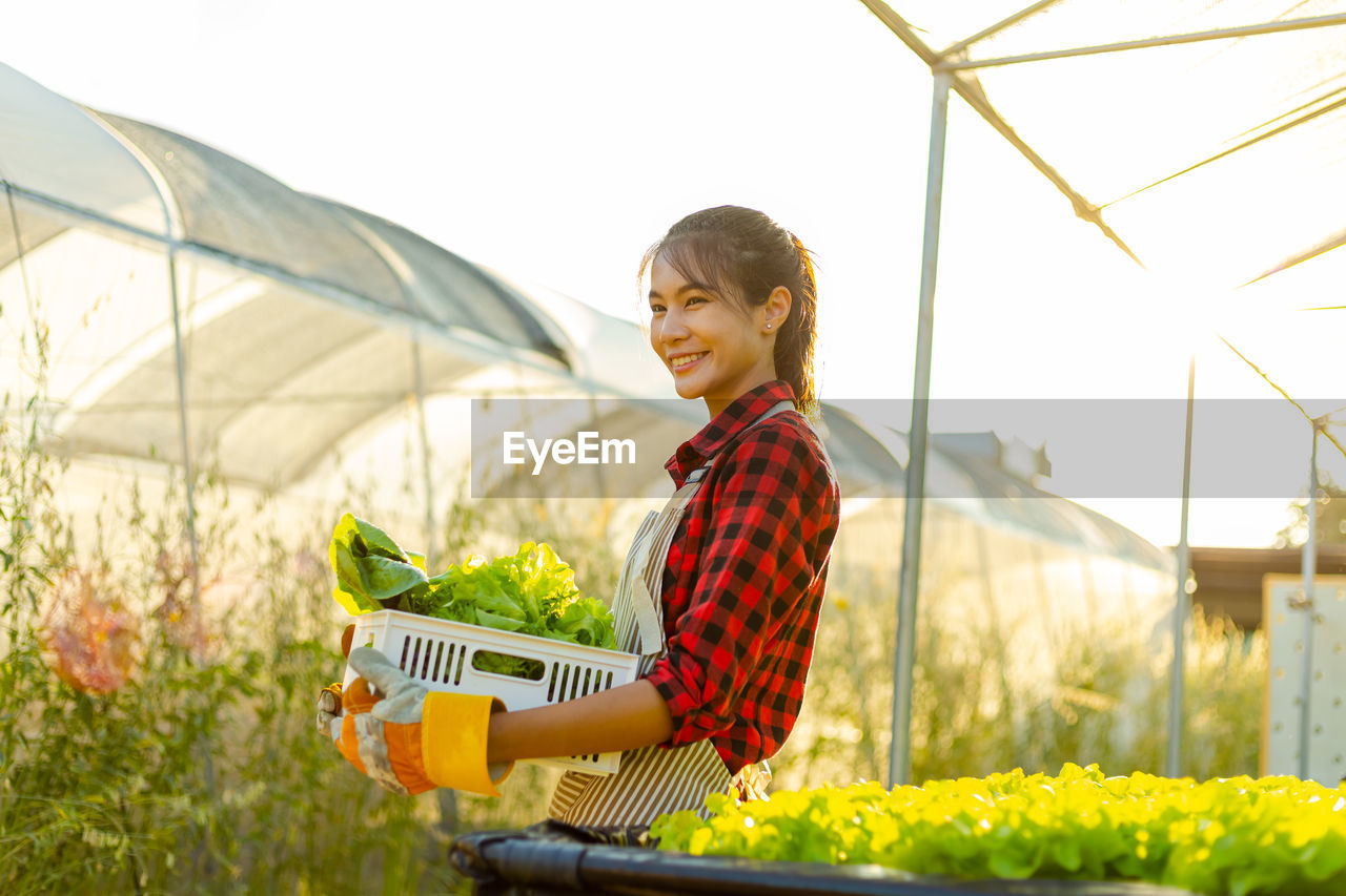 HAPPY MAN HOLDING UMBRELLA STANDING BY PLANTS