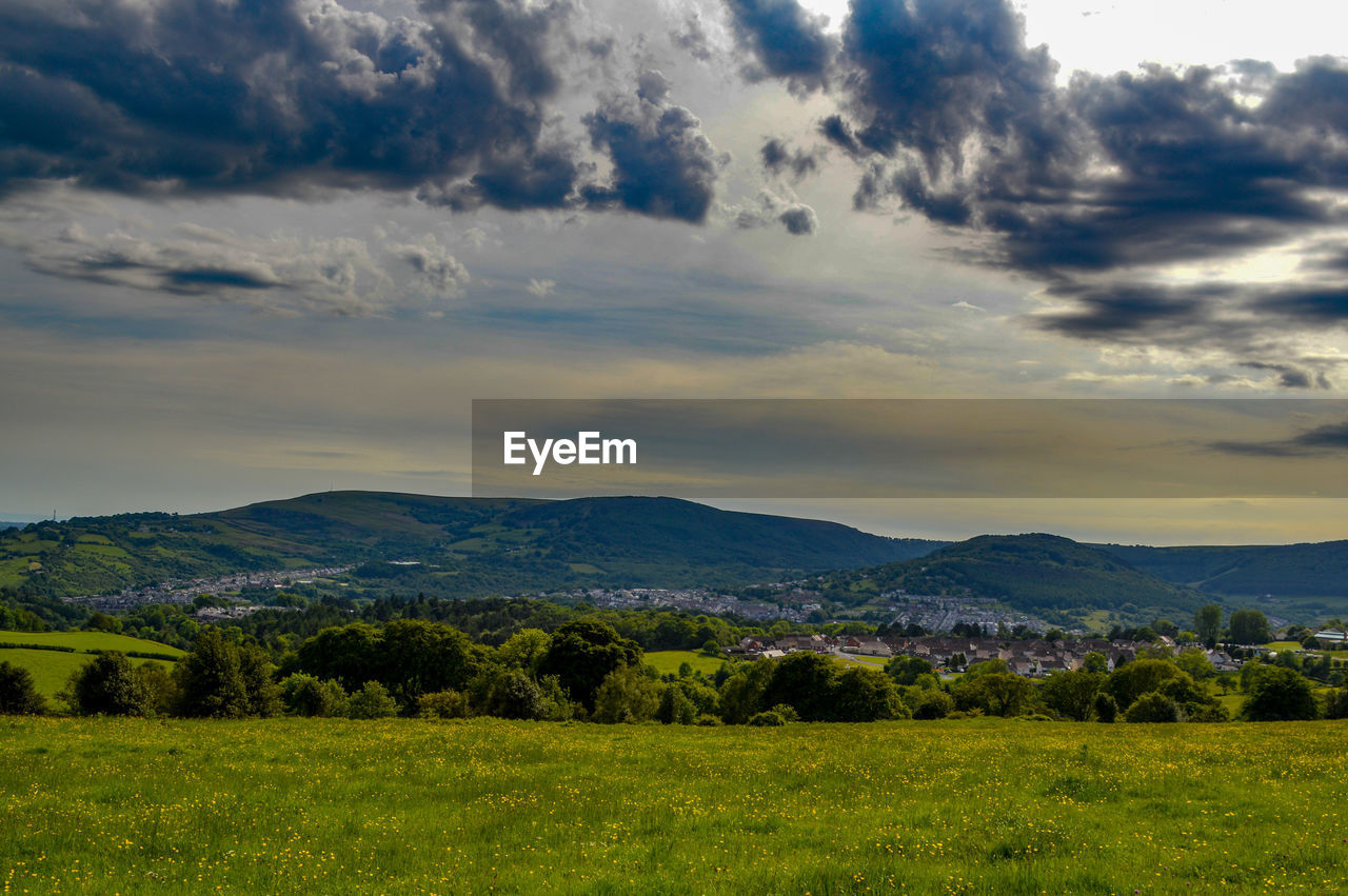 Scenic view of field against cloudy sky