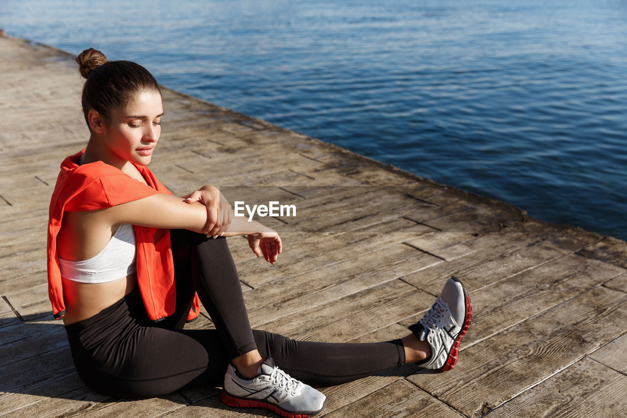 High angle view of woman exercising by sea