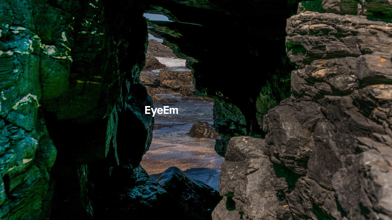 VIEW OF CAVE SEEN THROUGH ROCKS IN MIRROR