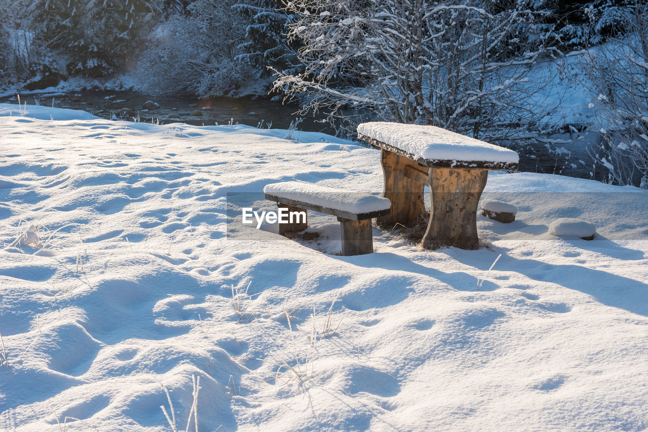 SNOW COVERED BENCH ON FIELD