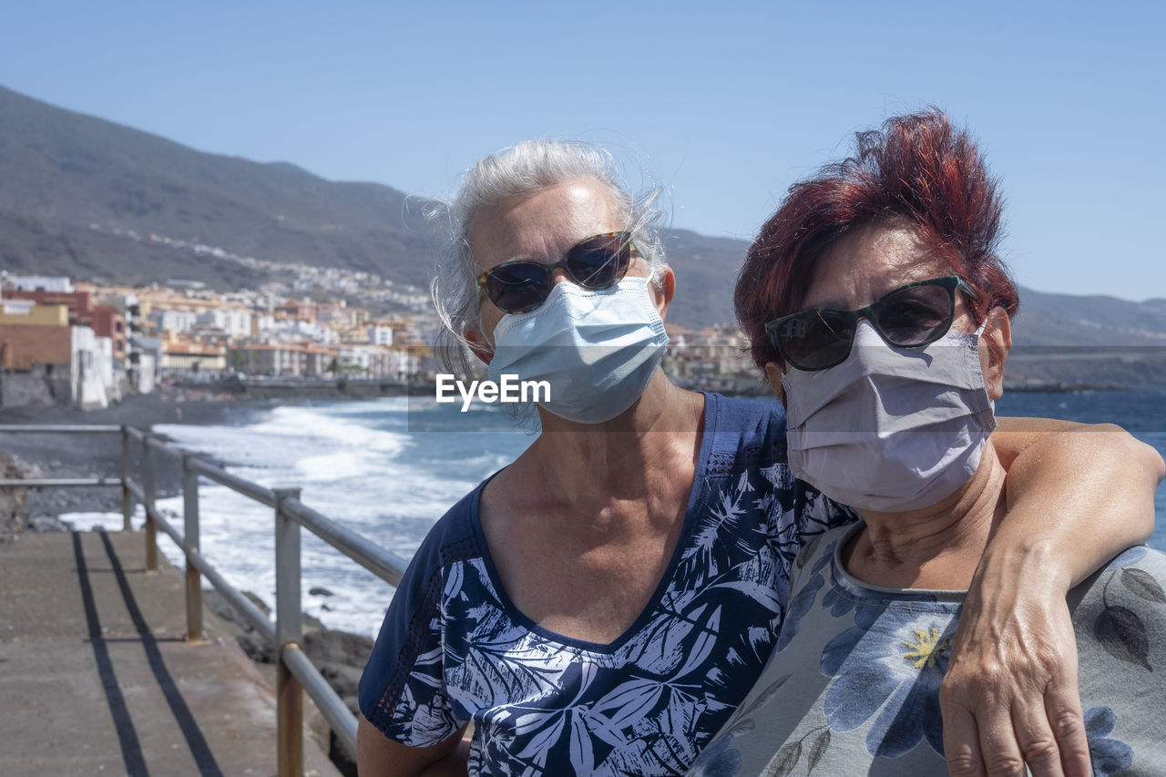 Portrait of senior women with sunglasses against sky