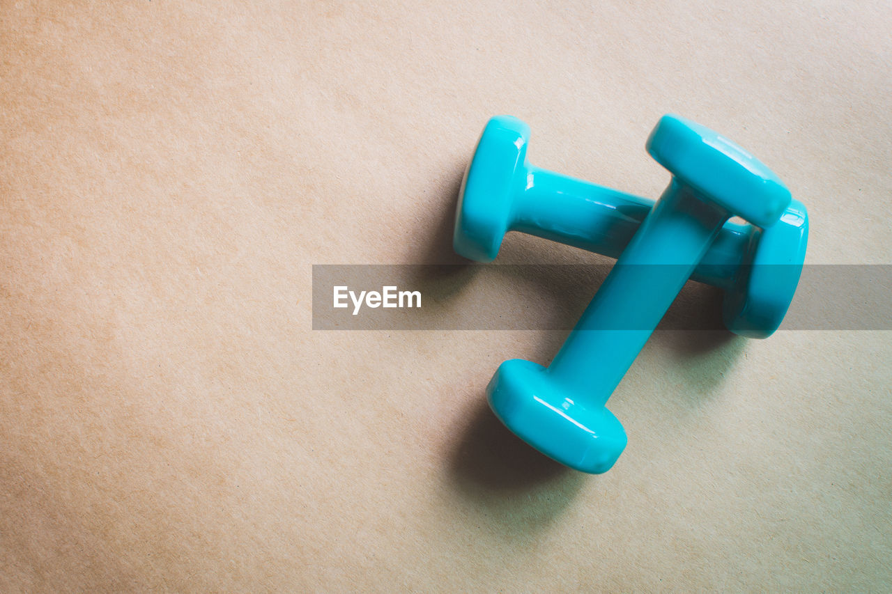 Directly above shot of dumbbells on pink table 