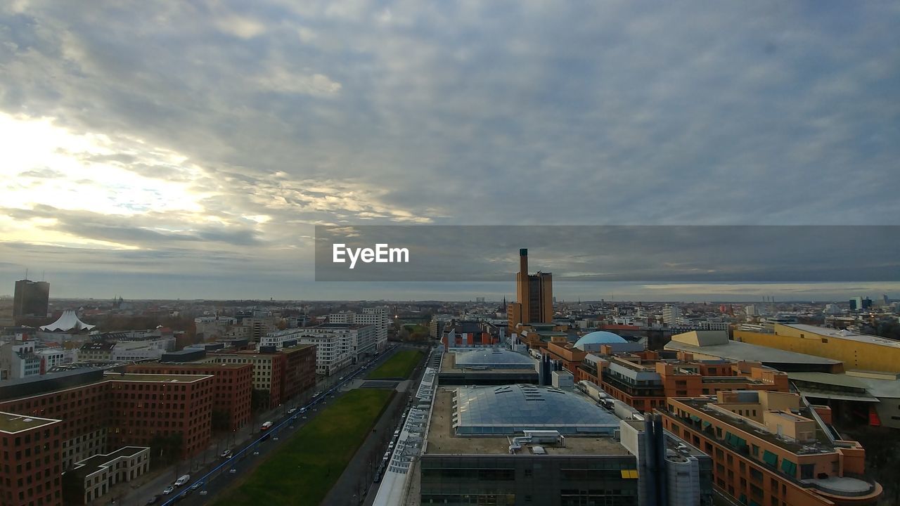 HIGH ANGLE VIEW OF STREET BY BUILDINGS AGAINST SKY