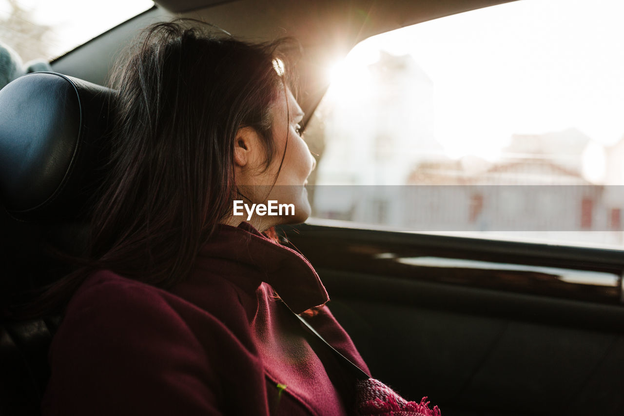 Relaxed woman in car st sunset. travel concept