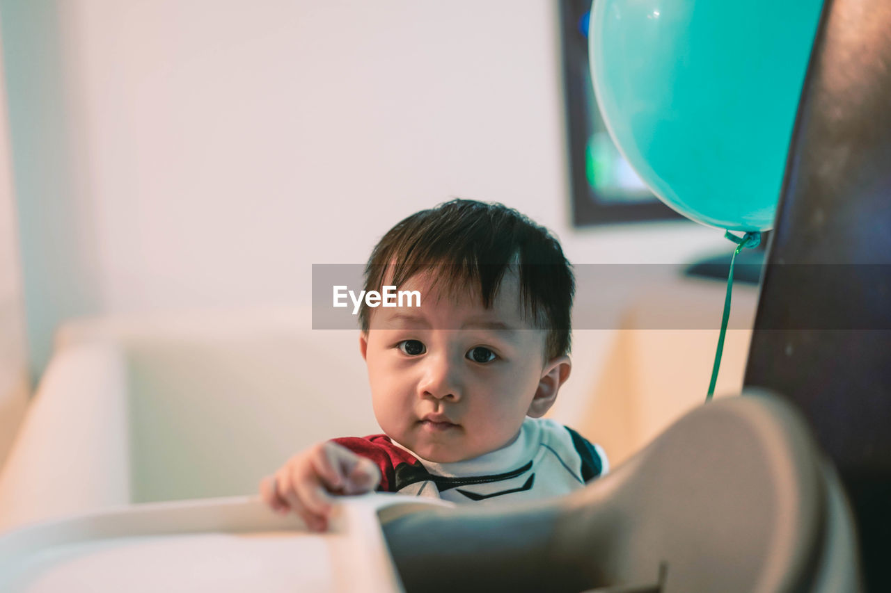 Portrait of cute baby boy sitting at home