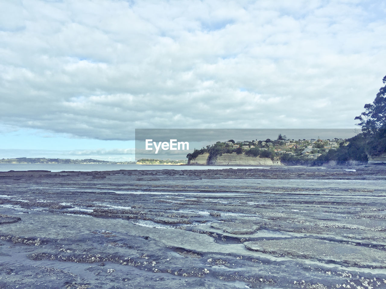 CALM BEACH AGAINST CLOUDY SKY