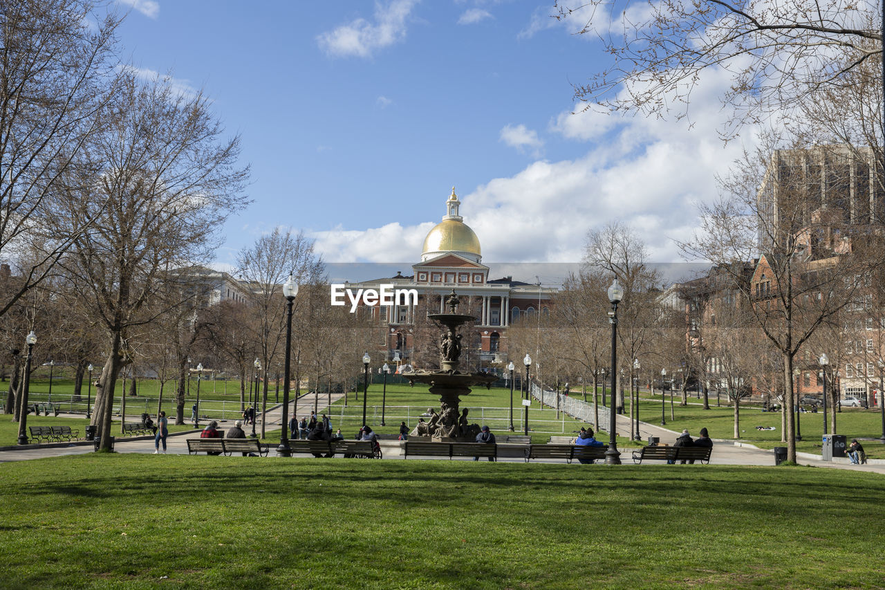 Massachusetts state house with park area and benches for people to relax