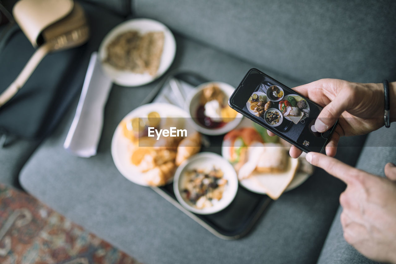 Hand of man taking photo with mobile in hotel room