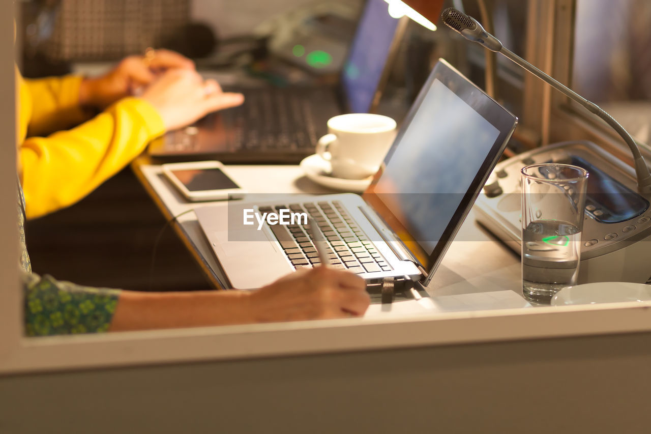 Business people using laptop at desk in office