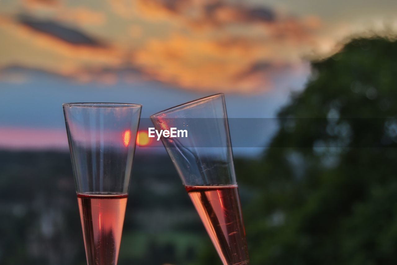 CLOSE-UP OF WINE GLASS AGAINST SUNSET