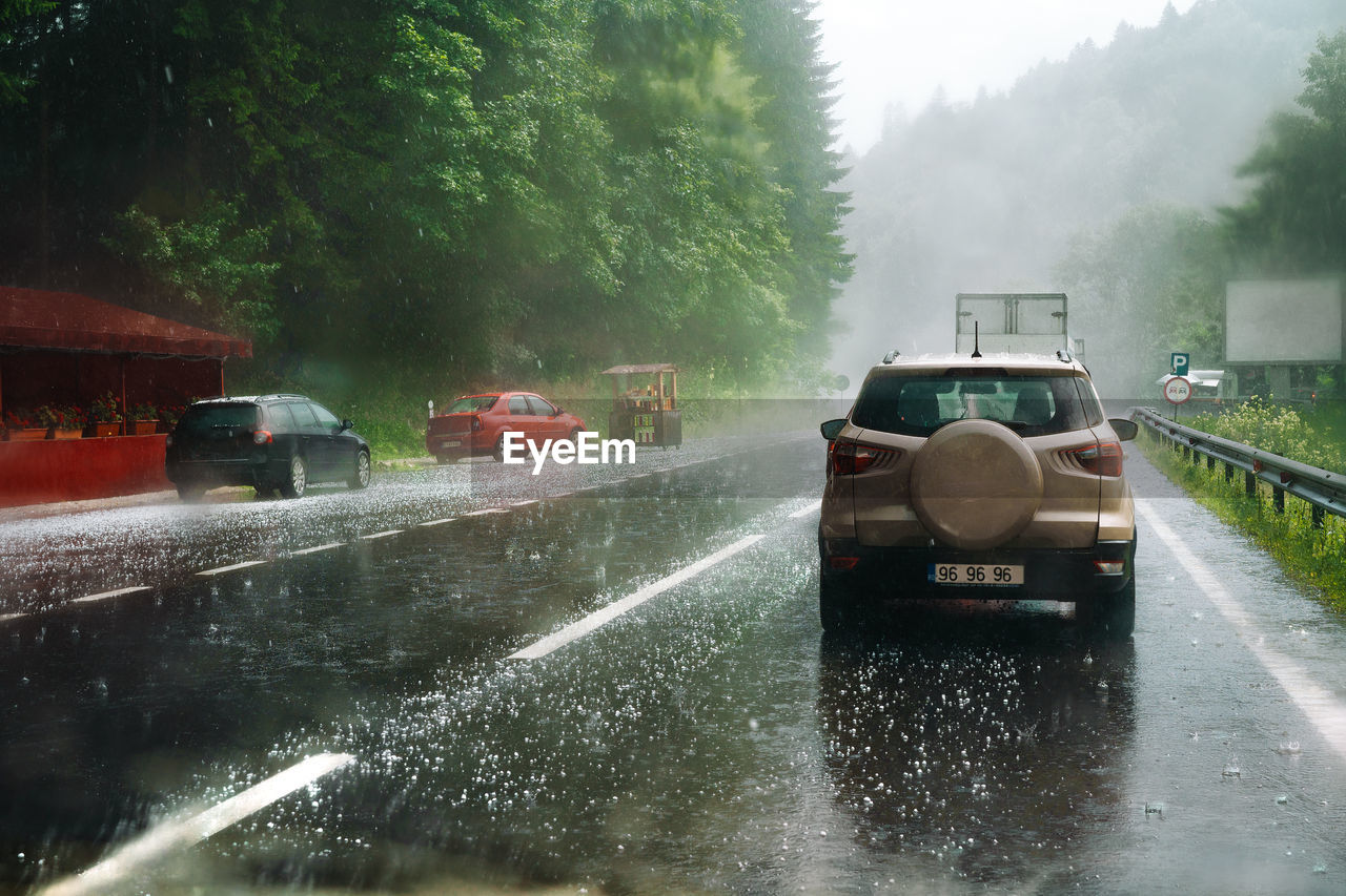 Cars on wet road during hail storm on mountain 