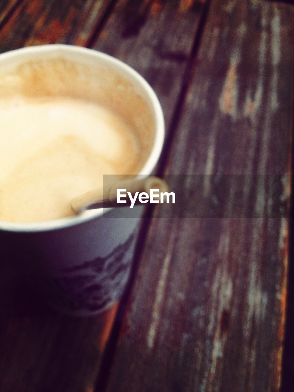 High angle view of drink served in cup on wooden table