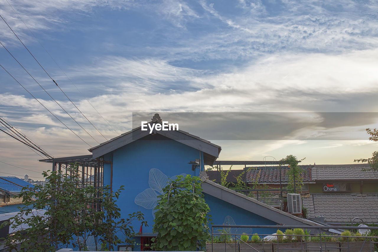 LOW ANGLE VIEW OF HOUSE AND BUILDINGS AGAINST SKY