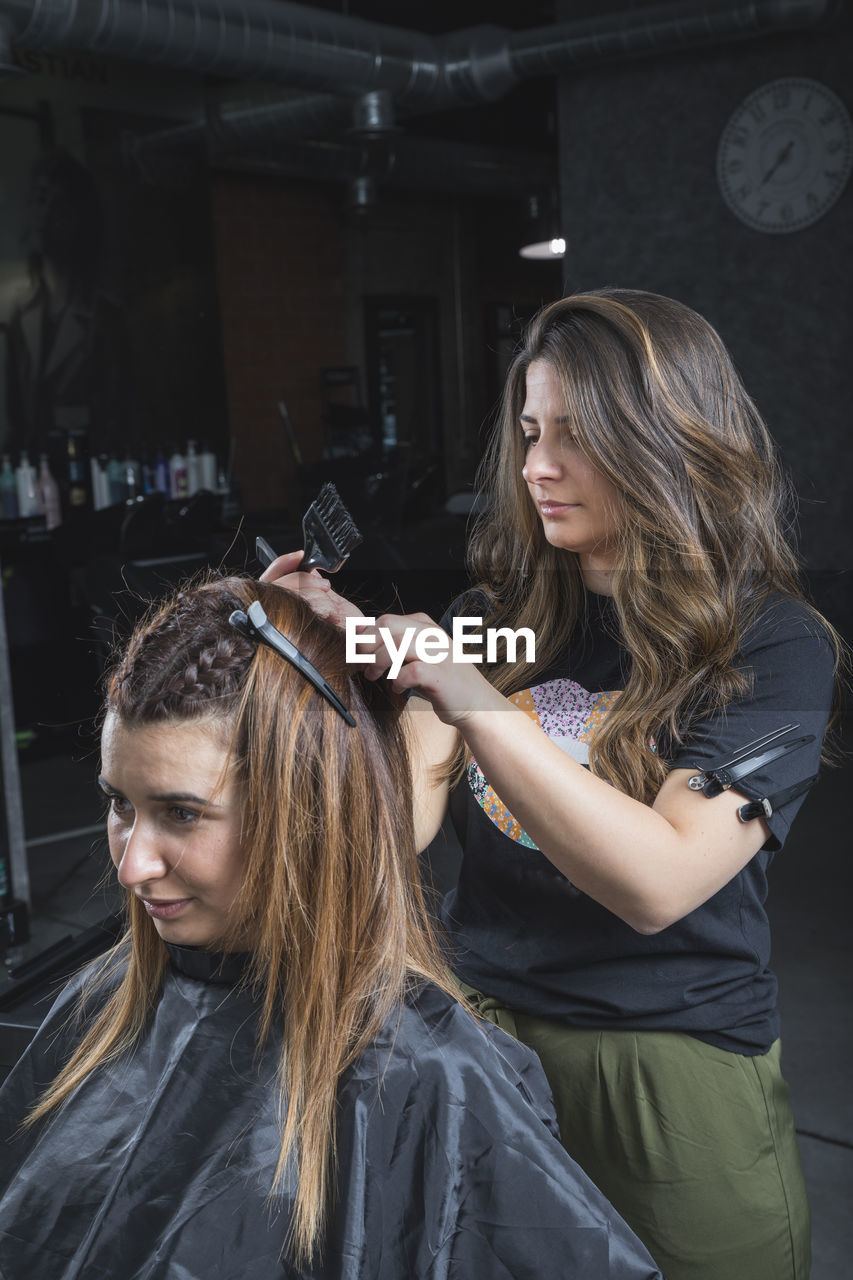 Hairdresser and beautician working in her hair salon