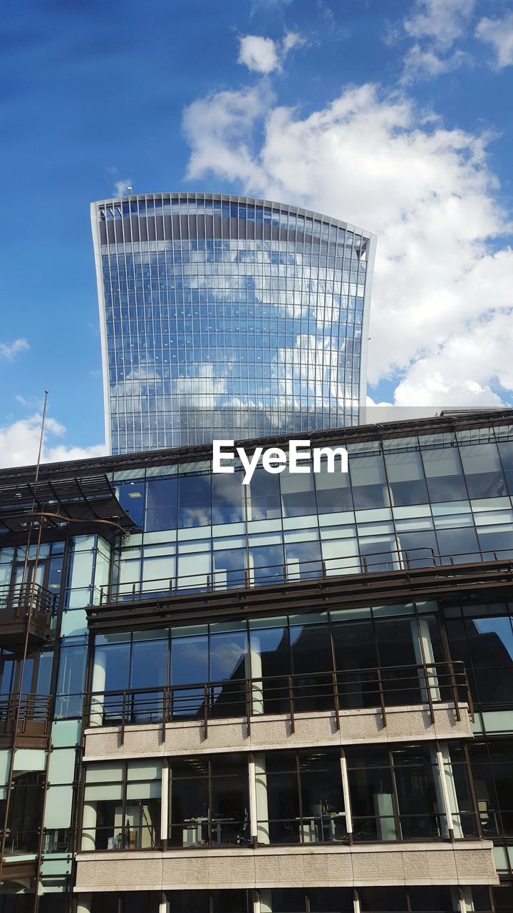 Low angle view of modern building against cloudy sky