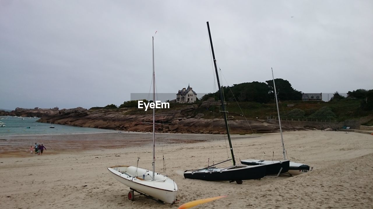 SAILBOATS MOORED ON BEACH