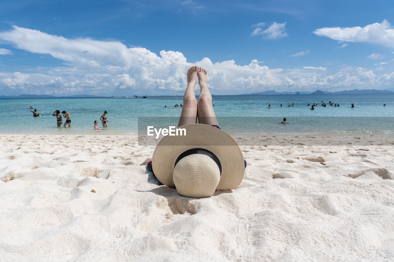 PEOPLE ON BEACH AGAINST SEA