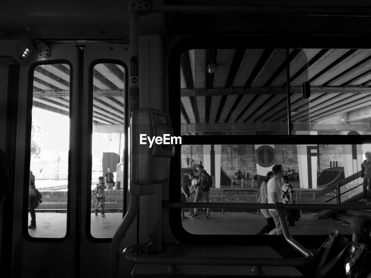 REAR VIEW OF MAN SITTING AT TRAIN