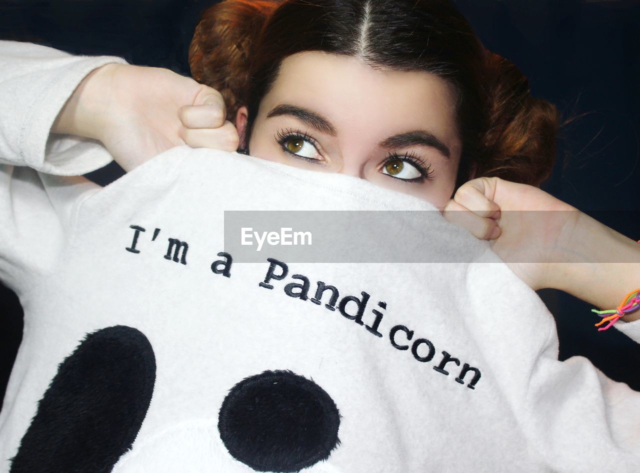 Woman looking away while holding t-shirt with text