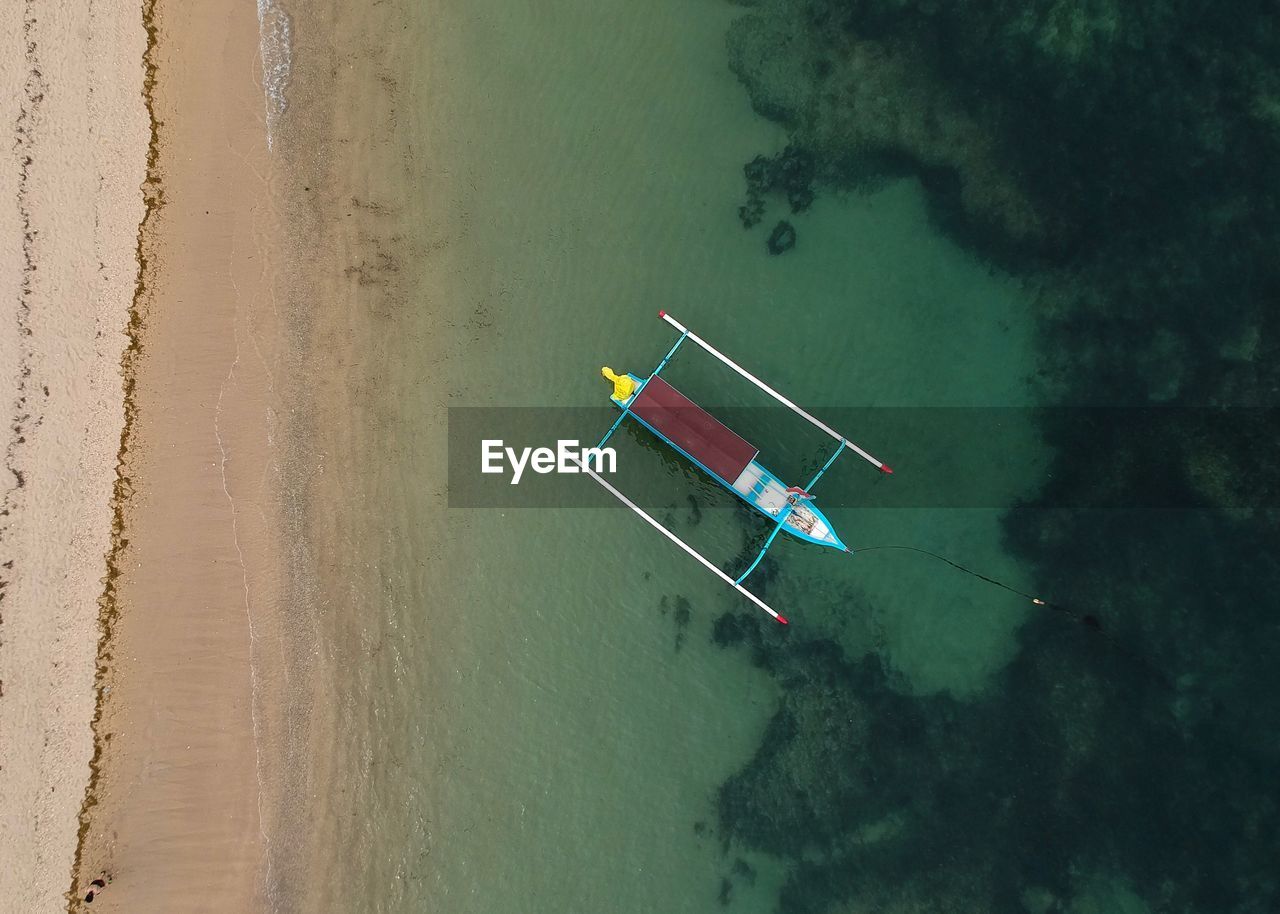 HIGH ANGLE VIEW OF MAN SAILING ON SEA