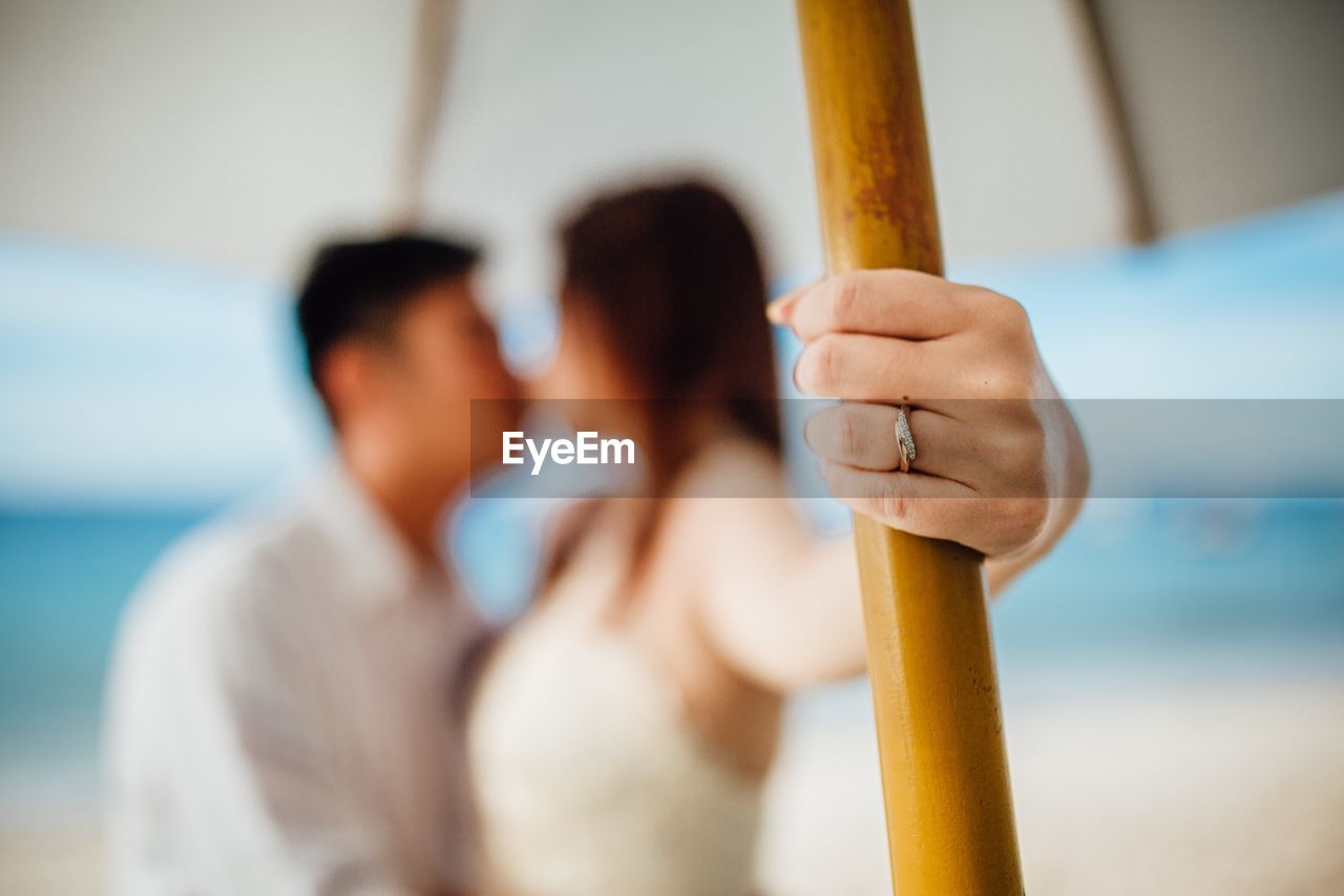 Close-up of couple kissing while standing at beach