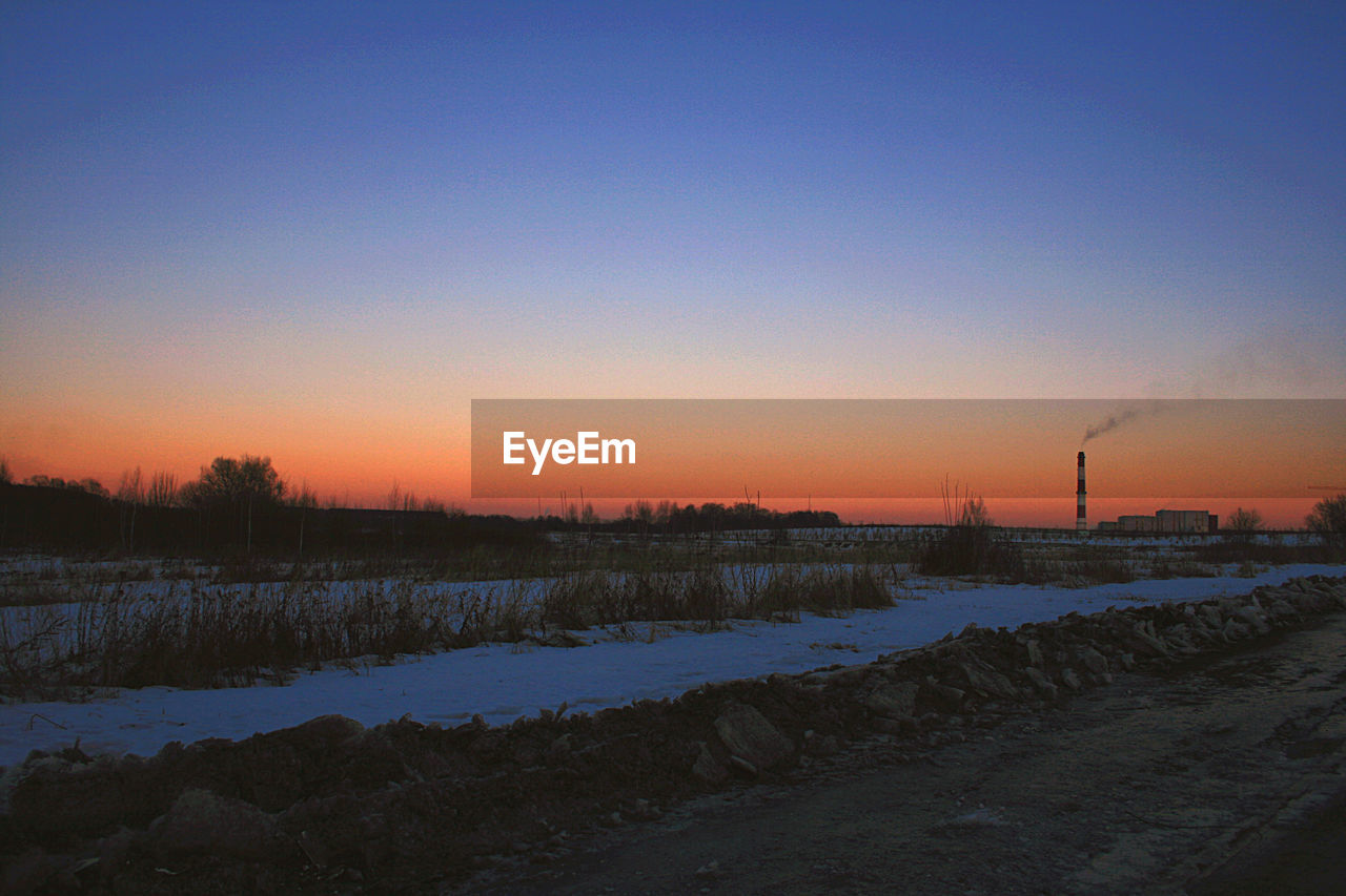 Scenic view of snow covered landscape against sky during sunset