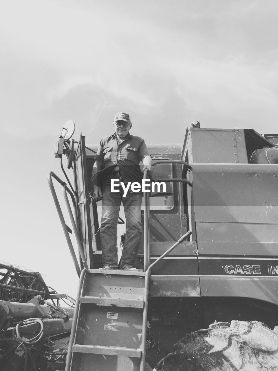 Low angle view of man standing on vehicle against sky