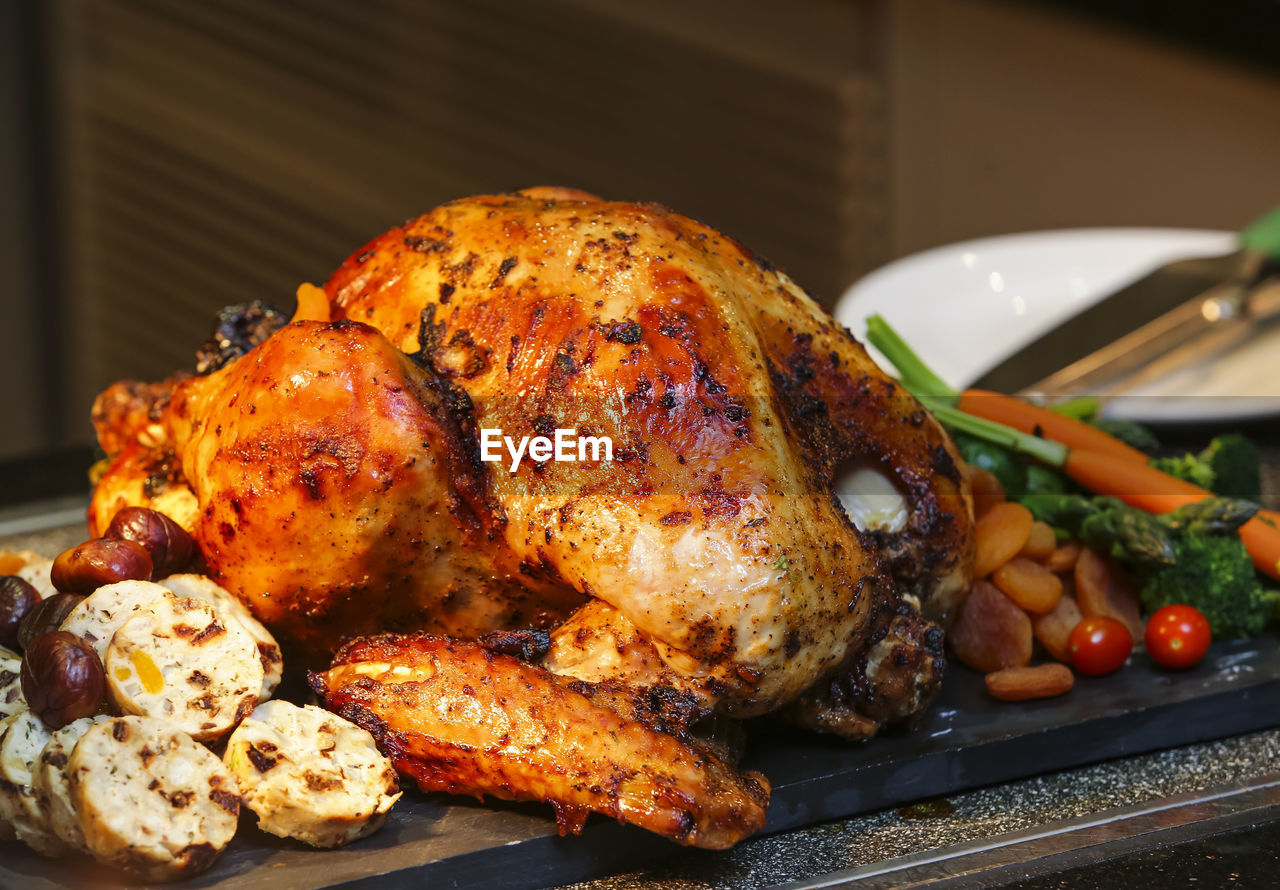 Close-up of roasted chicken on slate