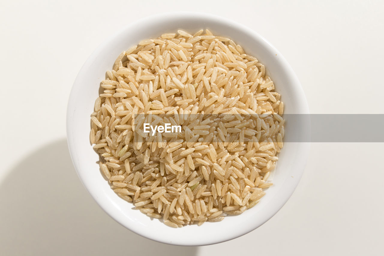 Close-up of rice in bowl over white background