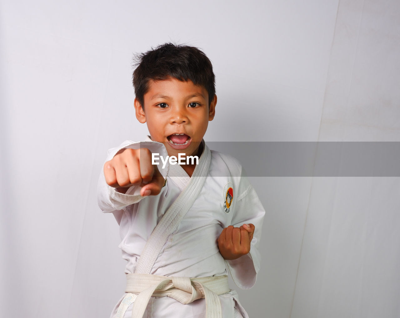 A child is demonstrating a martial arts punch