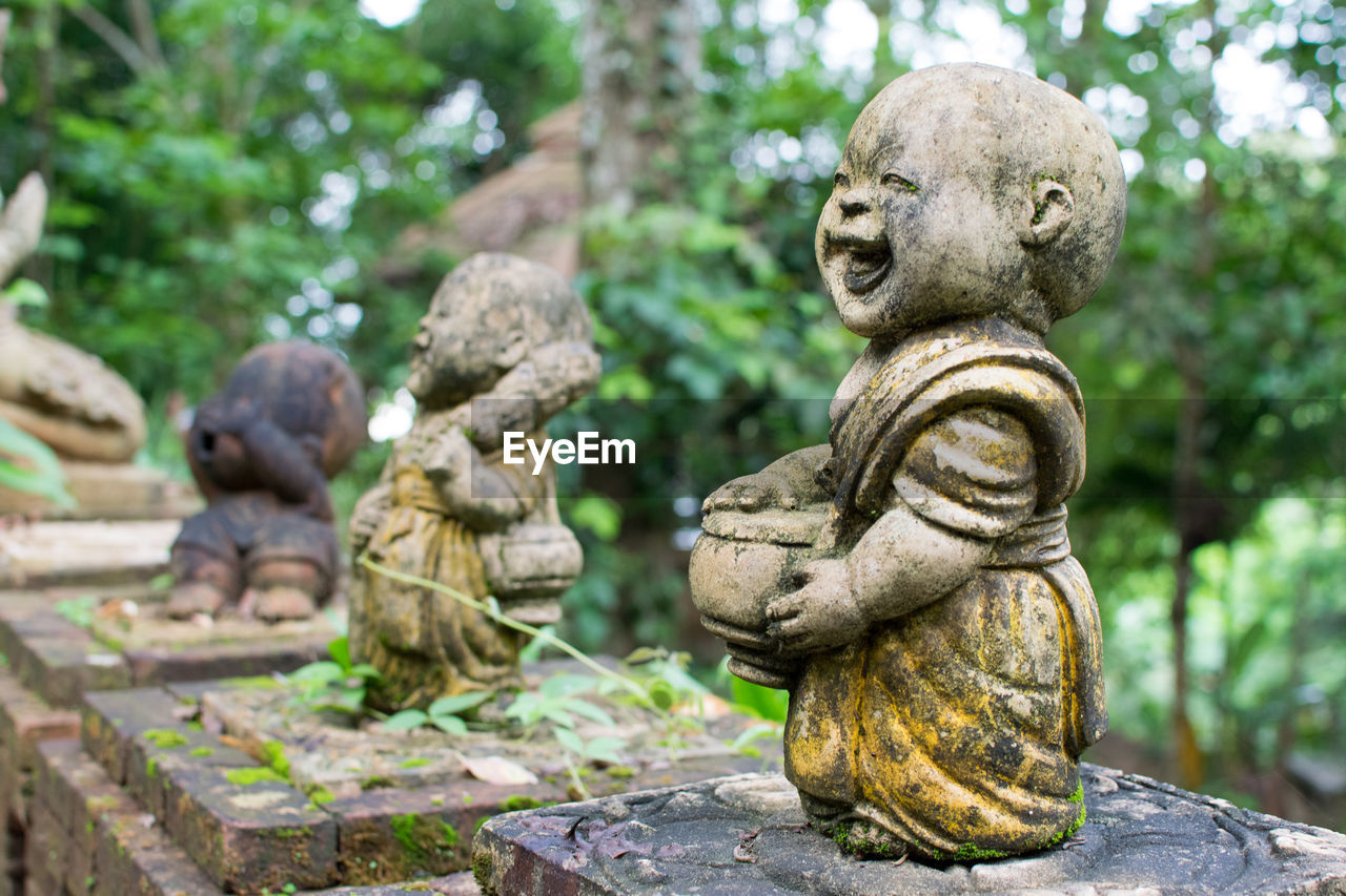 Baby monk ancient statue in temple of thailand