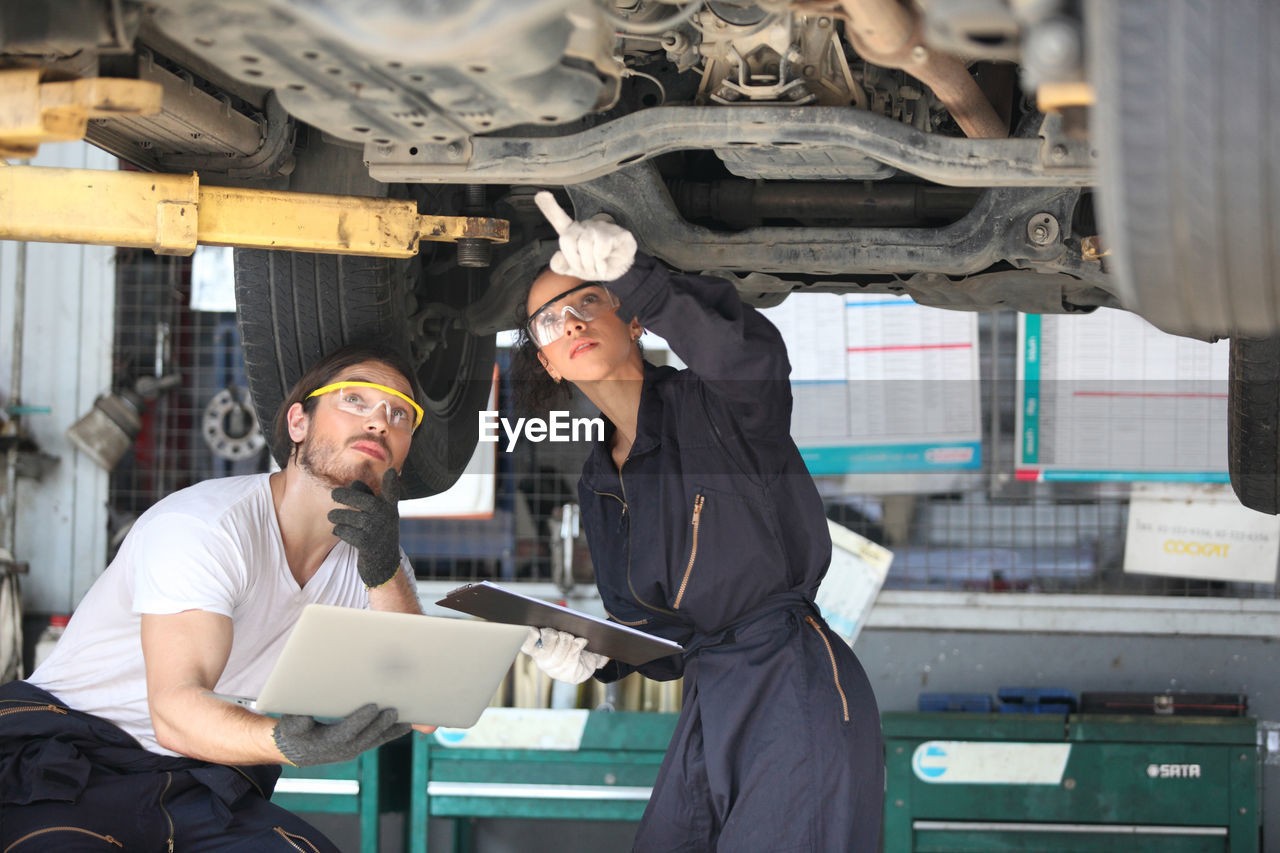 Young mechanics working at garage