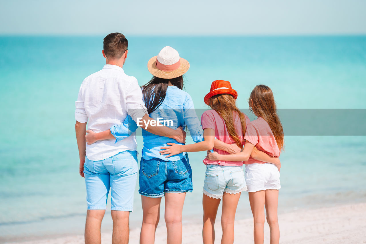 Rear view of family standing on beach